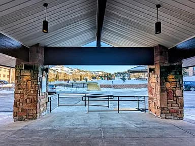 Covered stone entrance with snowy mountains beyond